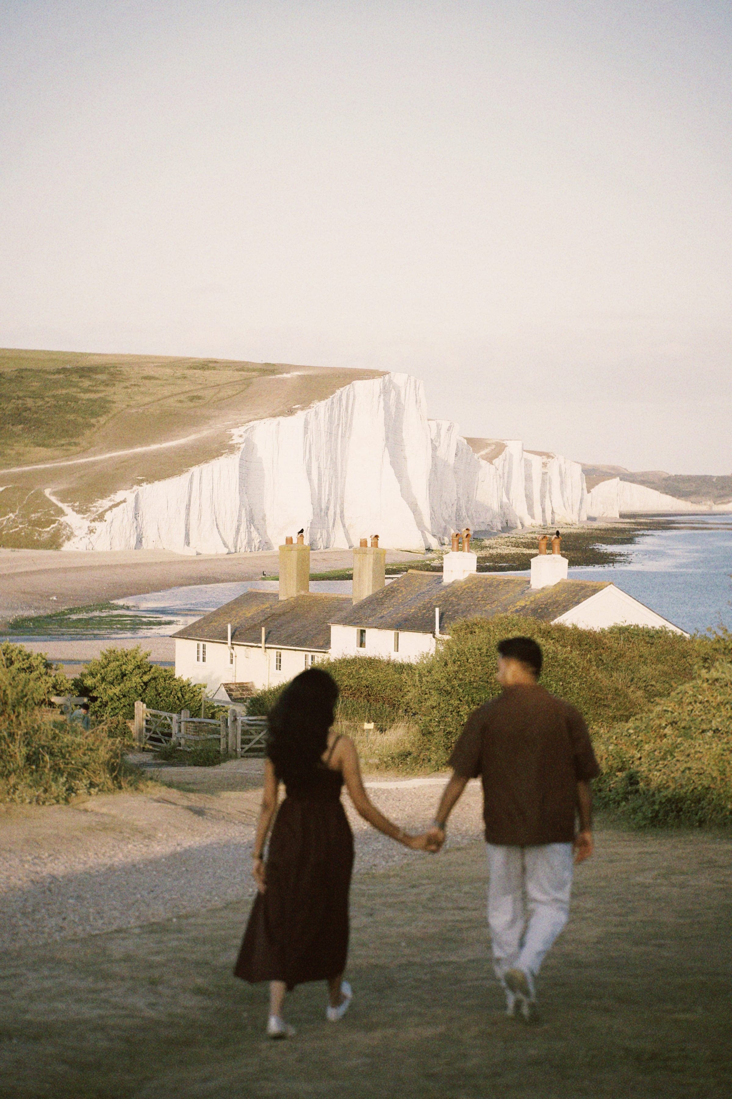 Arun and Anaina walking toward the cliffside cottages
